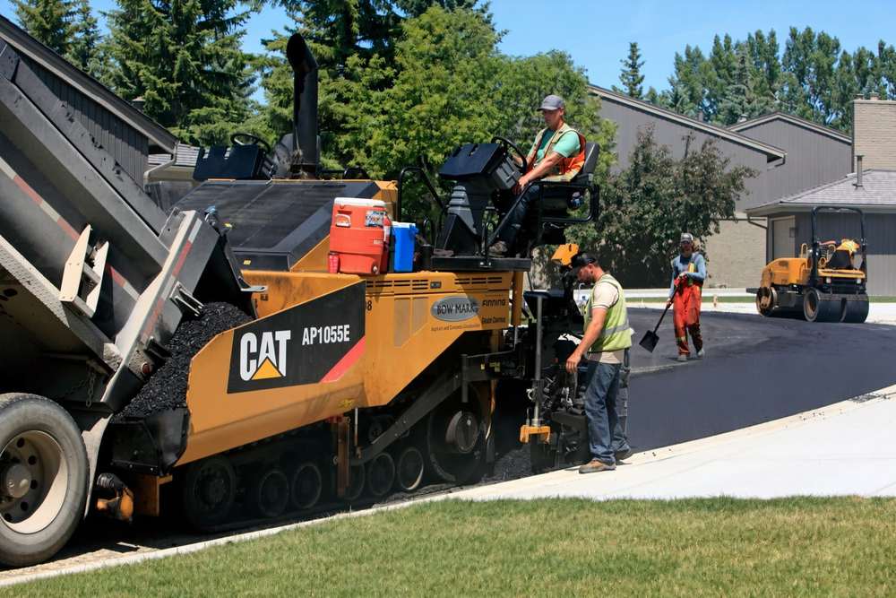 Knoxville asphalt repair crew compacting a hot mix patch on a residential driveway