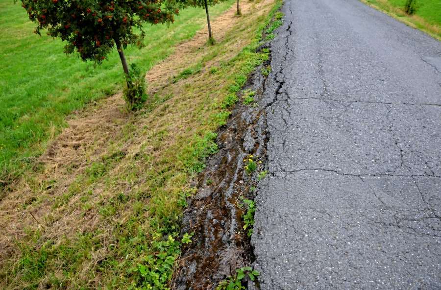 Crumbling asphalt driveway edge about to be rebuilt with new stone support and hot mix in Knoxville